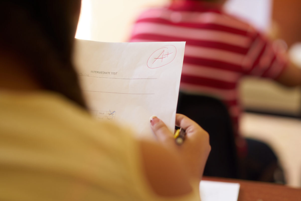 student with graded paper things to throw away