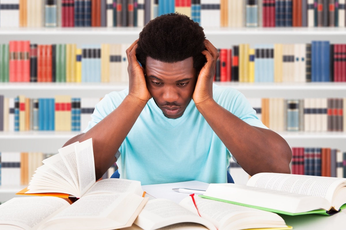 African American college student looking stressed in the library ways college is different