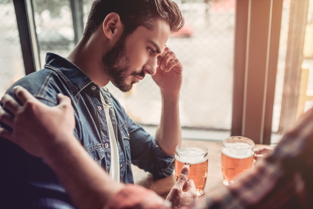 Upset man in bar. Friend's support