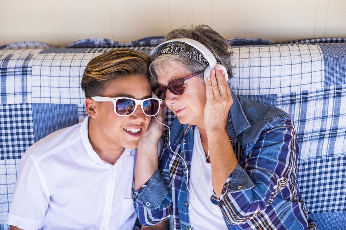 young man and older woman listening to music on couch