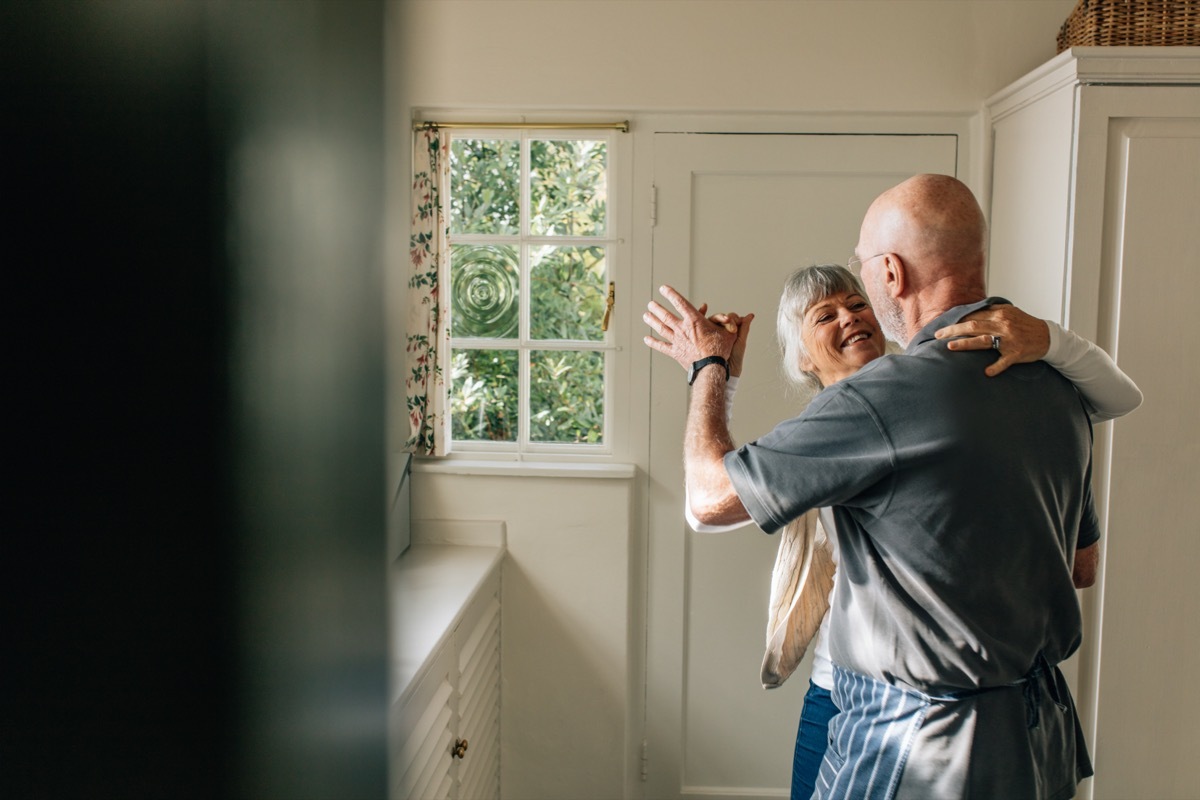 Mature couple dancing in their home