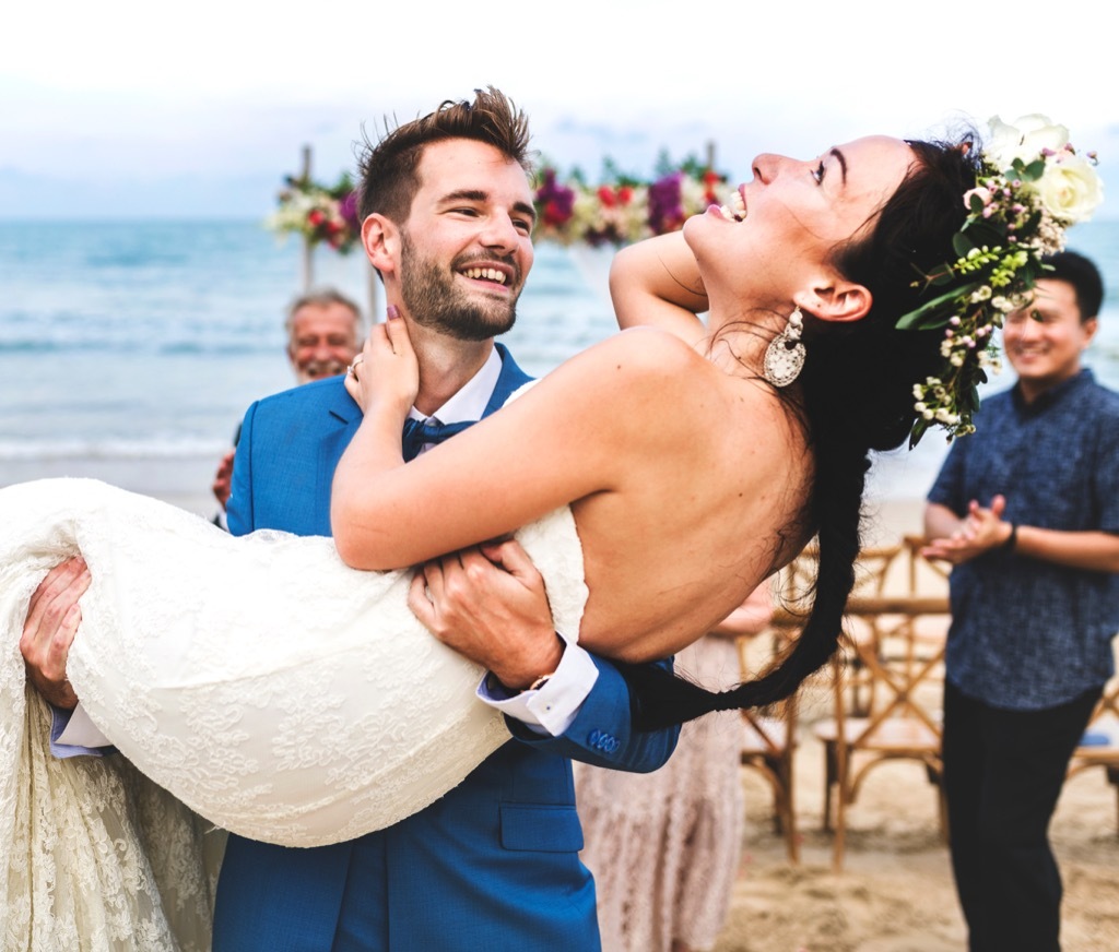 groom carrying bride 20 Old-Fashioned Wedding Traditions That Nobody Does Anymore