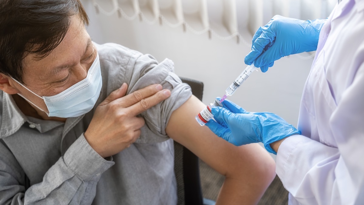 Doctor injecting Covid-19 coronavirus vaccine for older man