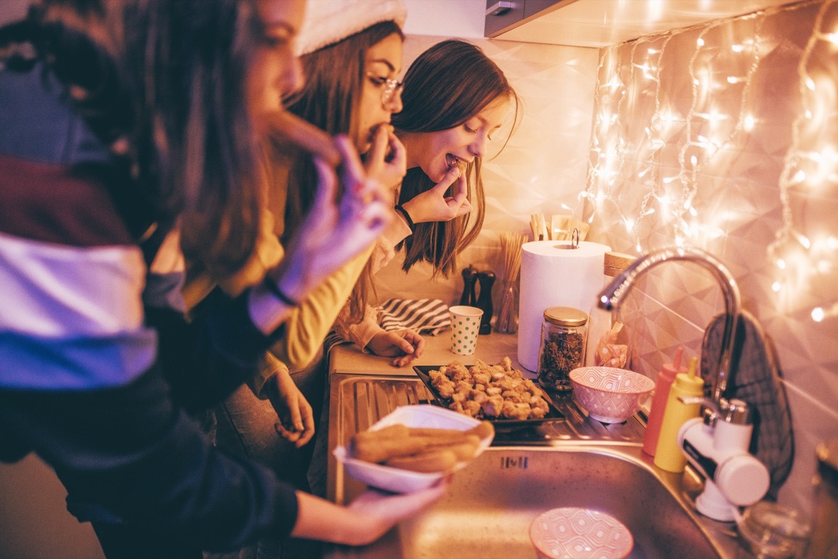 women eating chicken at a holiday party