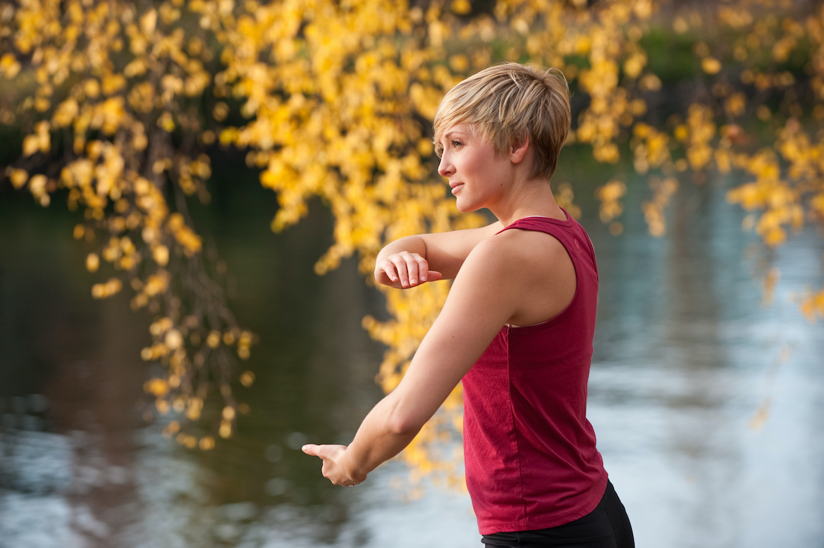 A young woman doing Tai Chi by a river