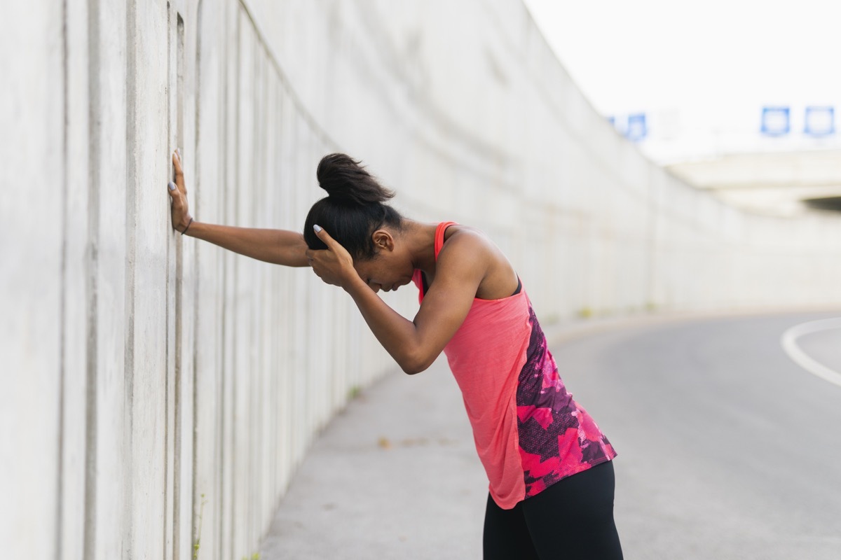 Woman feeling sick and dizzy while going for an outdoor run or jog