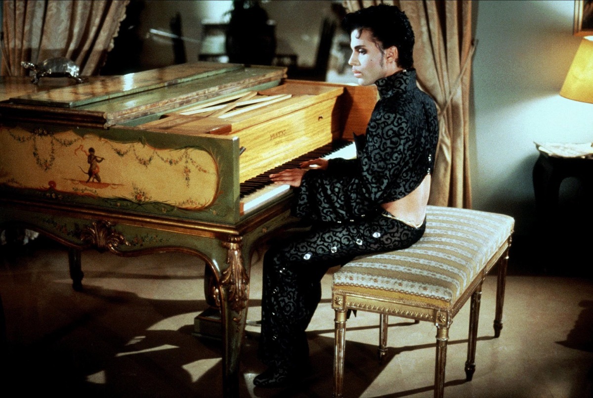 prince playing the piano while wearing a crop top