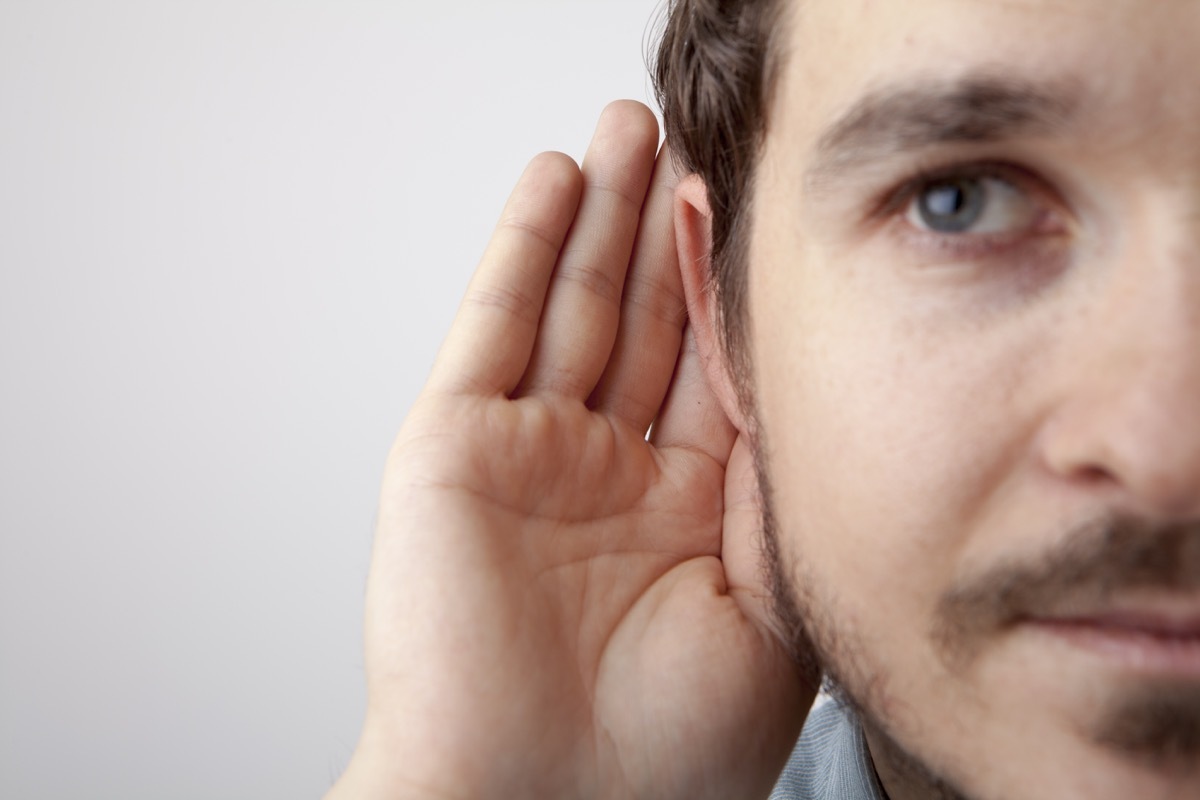 man. cupping his ear, listening