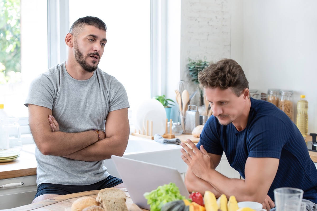 Mature caucasian gay male couple having an arguement while having breakfast in the morning at home