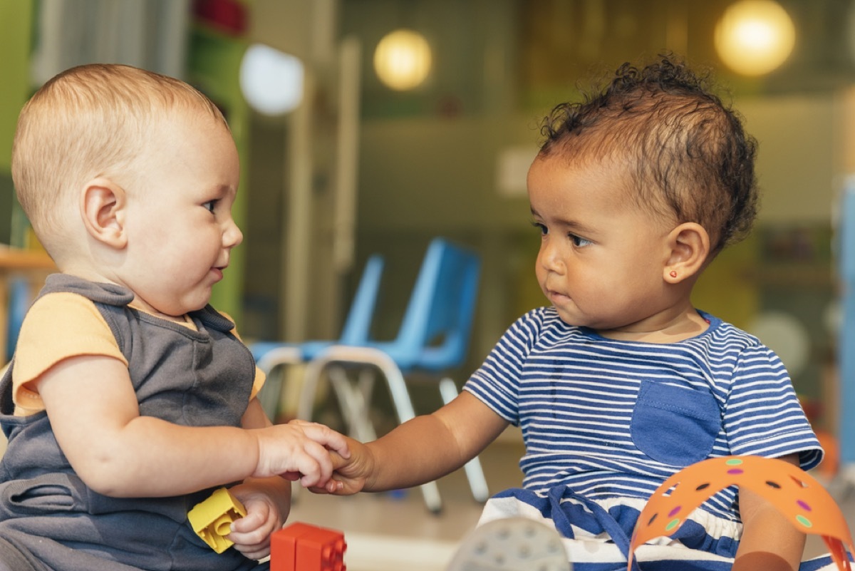 two babies playing with blocks together