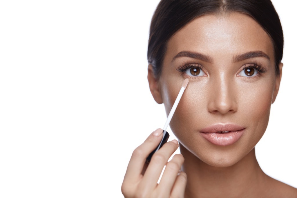 woman applying concealer makeup Body Flaws