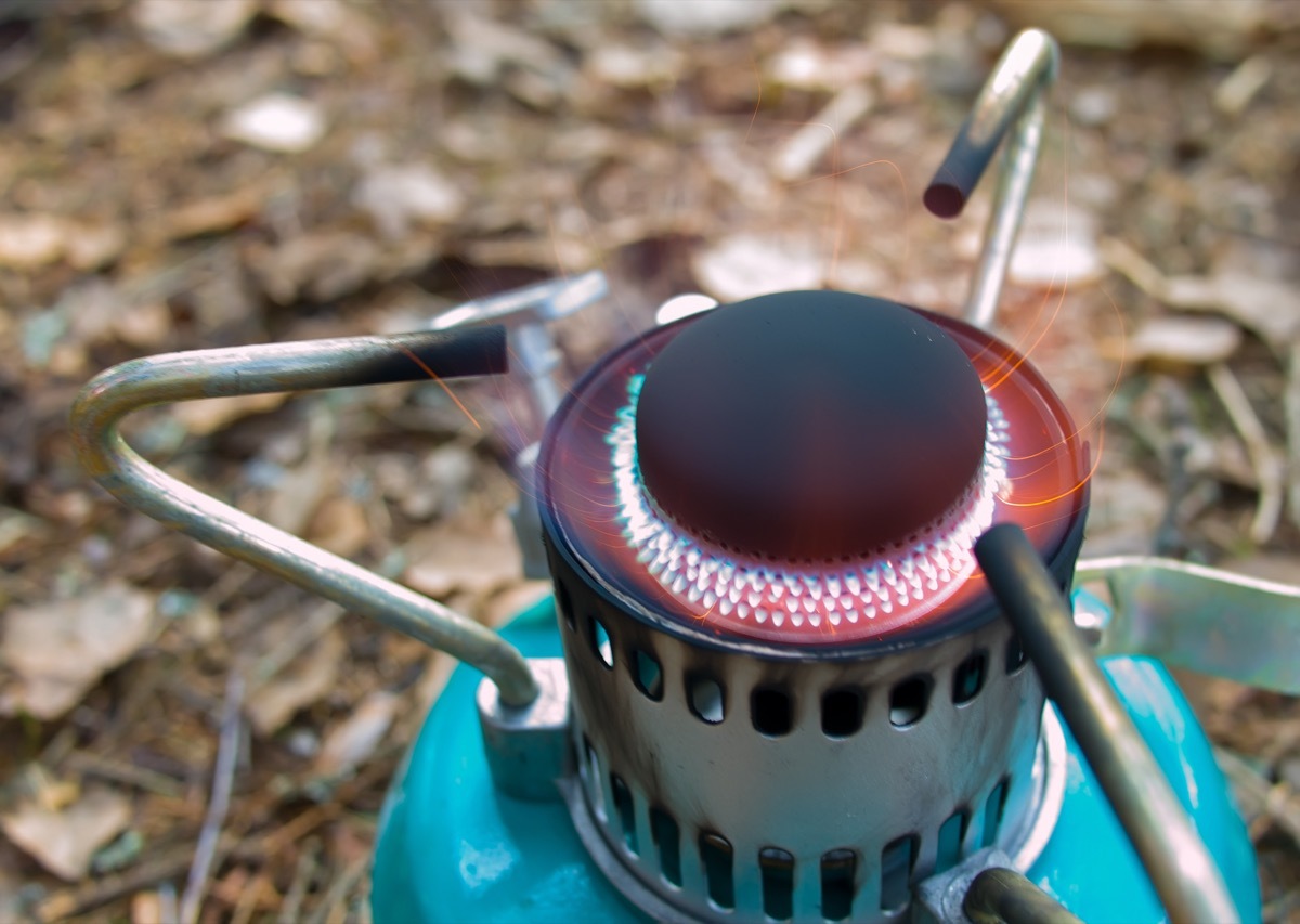 green kerosene lamp or camping stove in woods