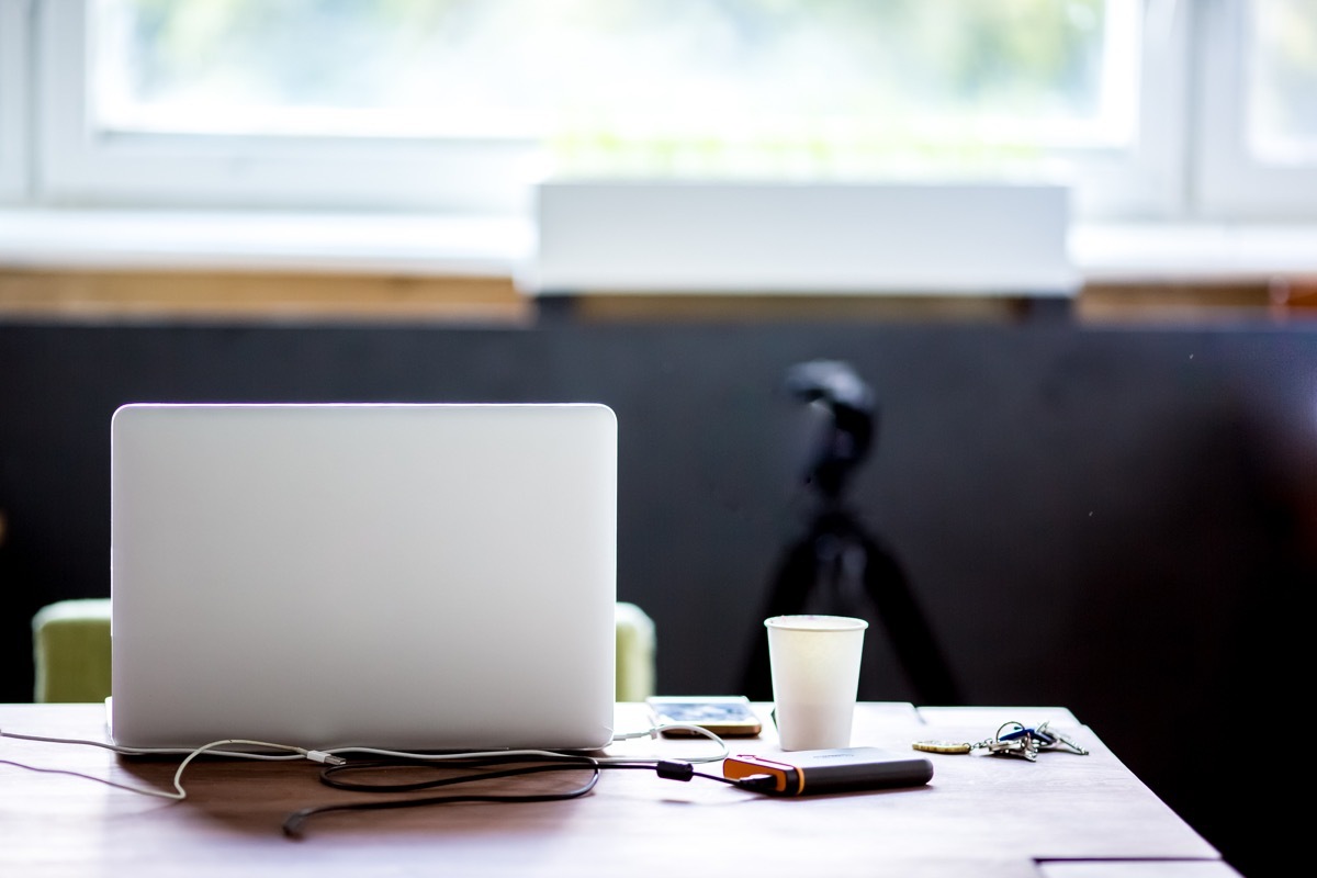 laptop open on a table next to a coffee cup, trademark failures