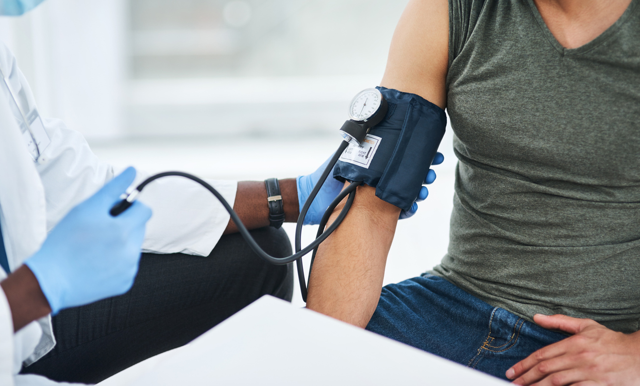 Doctor examining a patient with a blood pressure gauge.