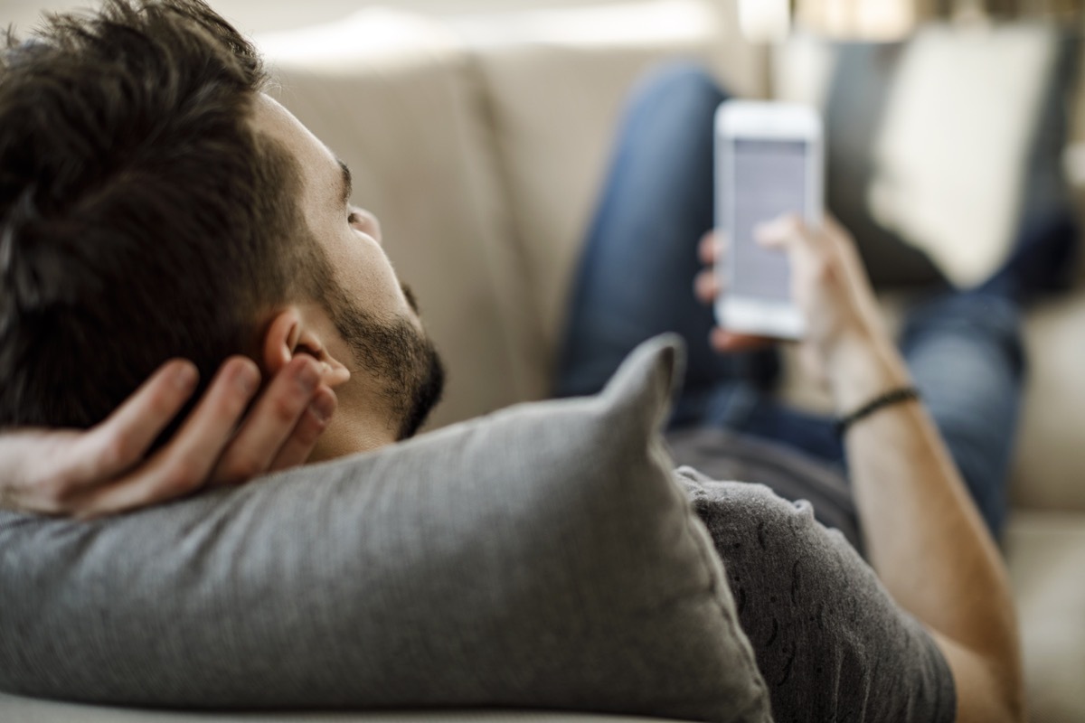 Young man using mobile phone at home