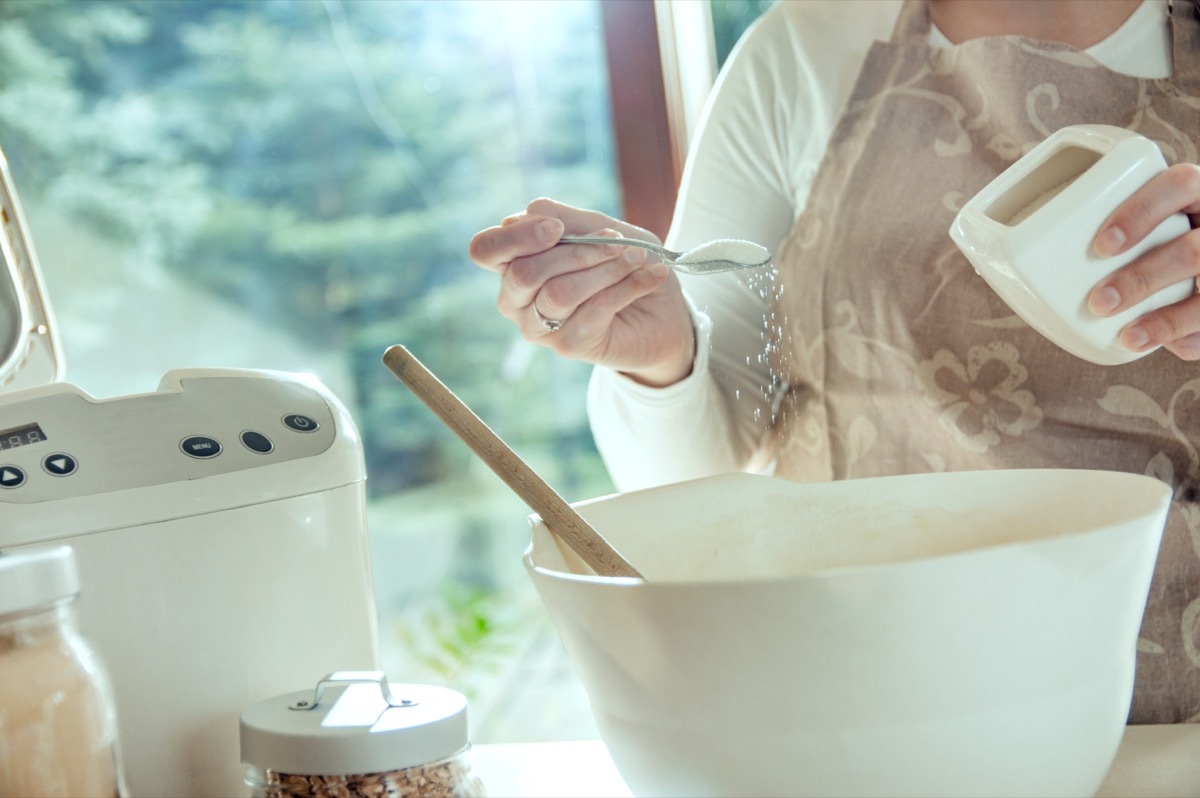 Woman pouring salt into a large bowl for recipe