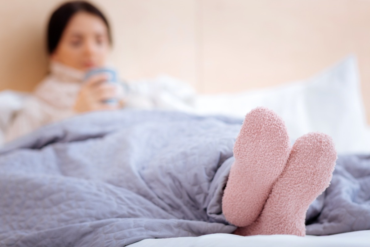 Warm pink socks of an ill young woman