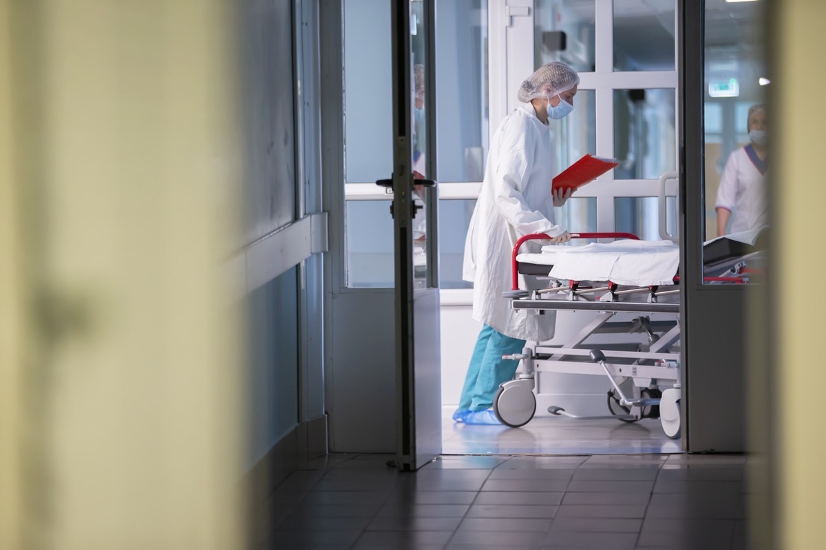 A nurse pushes a gurney with a stretcher in the hospital corridor.Hospital corridor.