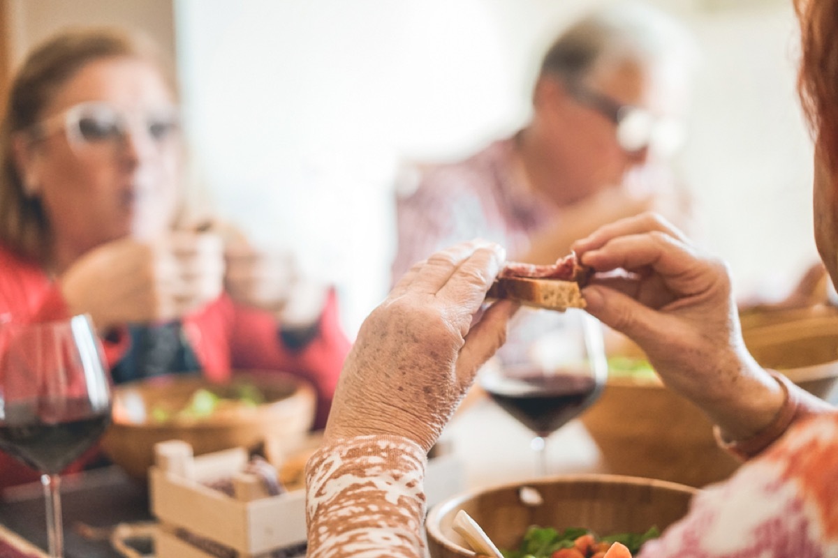 woman eating sandwich at dinner table