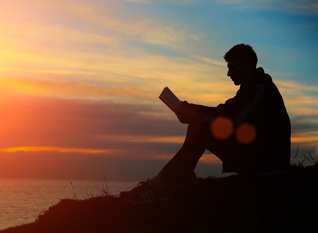 man reading at sunset