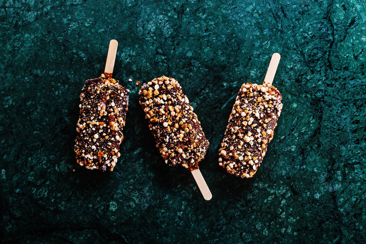 Peanut butter chocolate ice cream popsicles on dark marble table