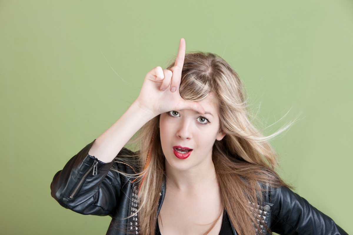 woman holds an L on her forehead for the loser sign