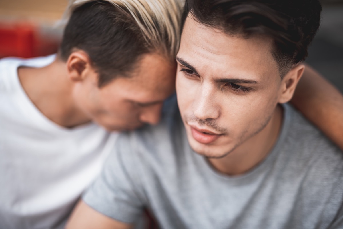 sad man putting his head on his partner's shoulder