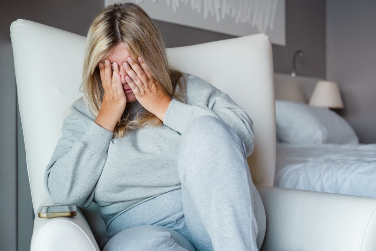 woman covering her face while stressed