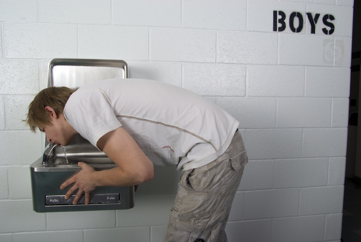 Student drinking from a water fountain at school