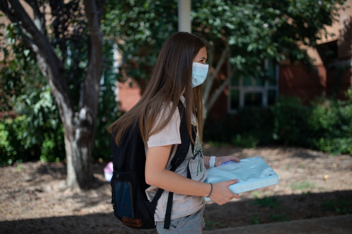 Girl back to school wearing a mask to protect from Coronavirus